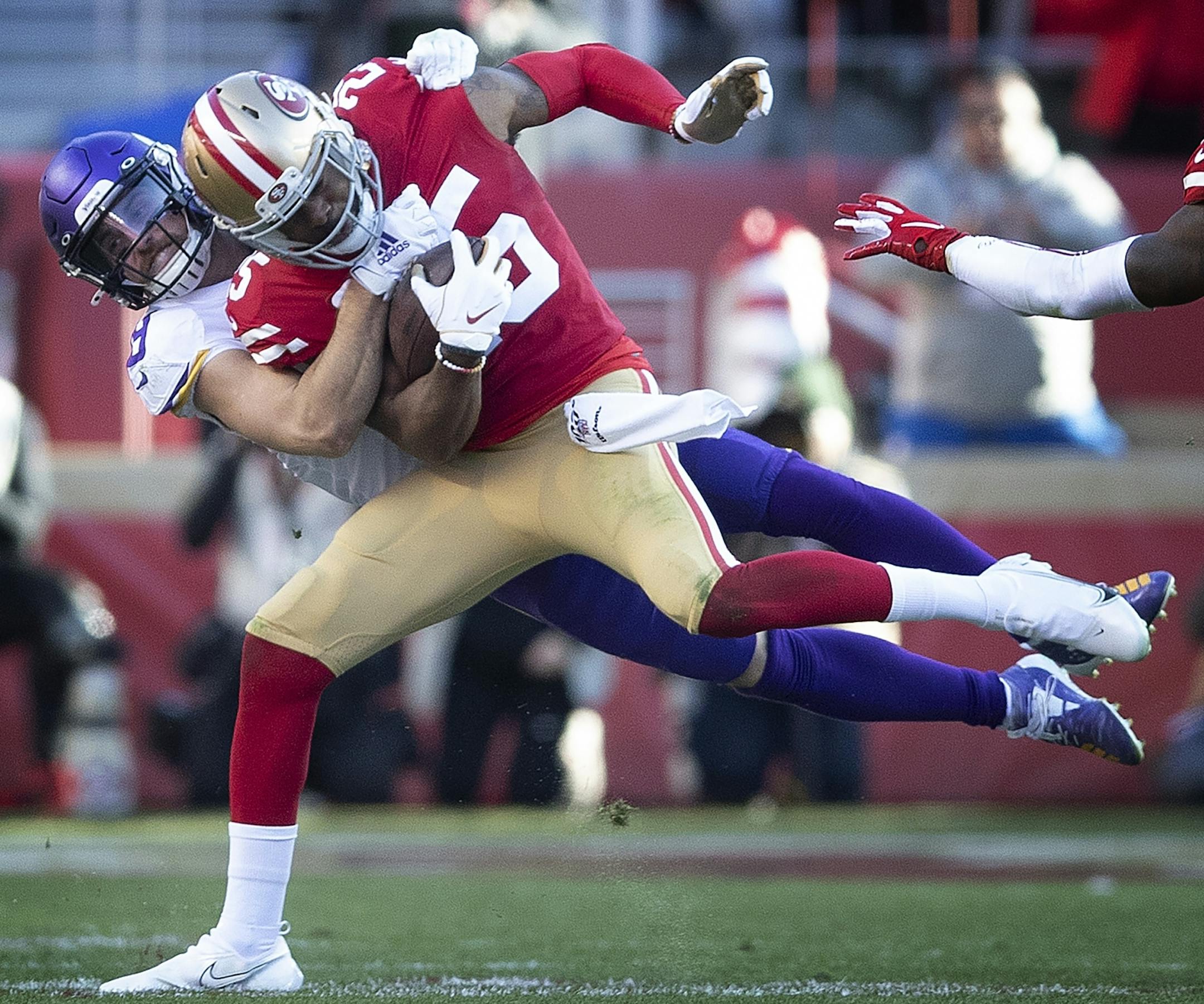 Minnesota Vikings wide receiver Adam Thielen (19) tackled San Francisco 49ers cornerback Richard Sherman (25) after he intercepted at third quarter pass .