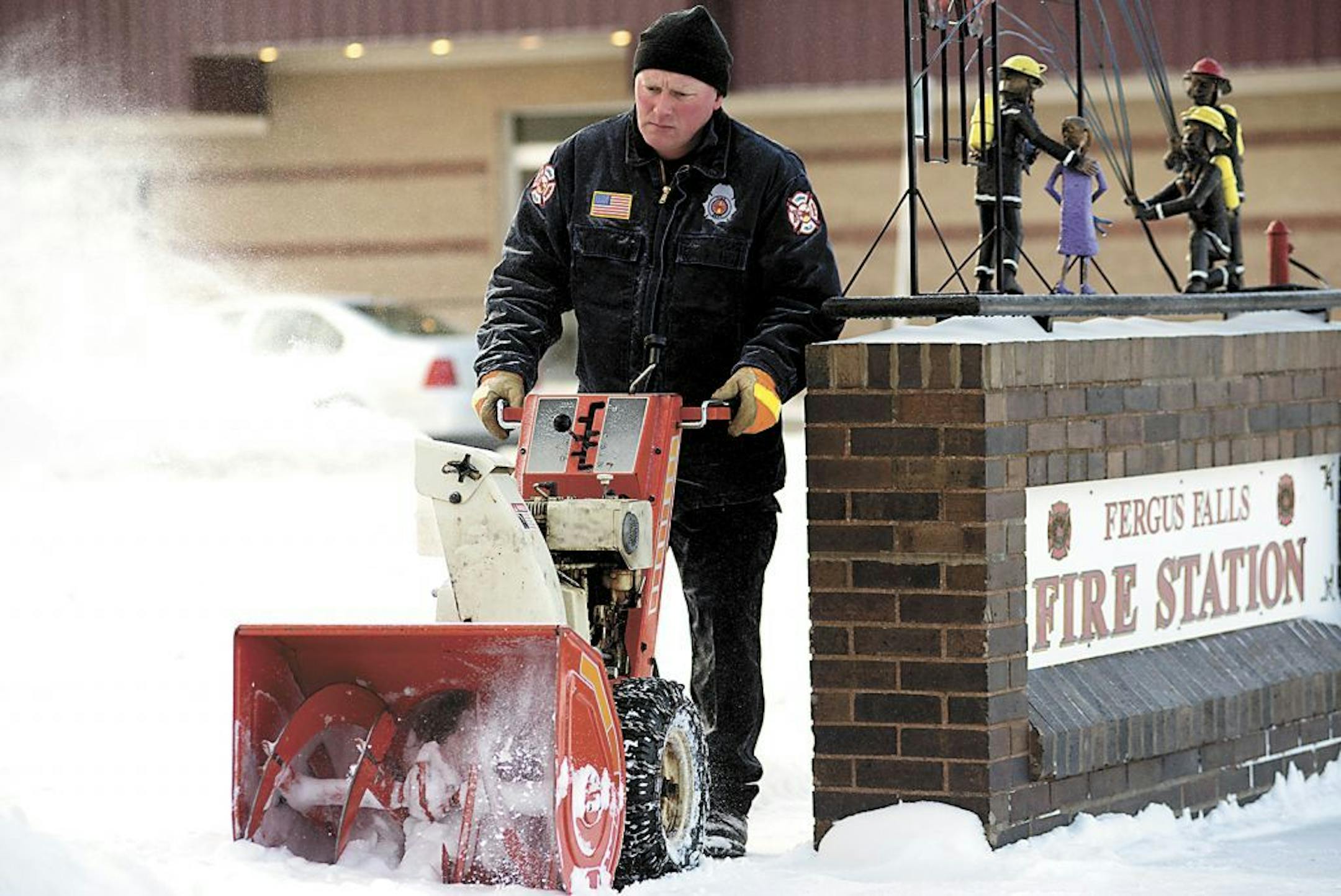 Craig Hebert blows snow from the front walk of the Fergus Falls fire station, Tuesday, April 1, 2014, in Fergus Falls, Minn. A spring blizzard that dumped heavy amounts of snow in parts of the Upper Midwest on Monday.