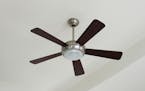 Silver and wood ceiling fan with a light on a white ceiling. (Dreamstime/TNS) ORG XMIT: 1197156