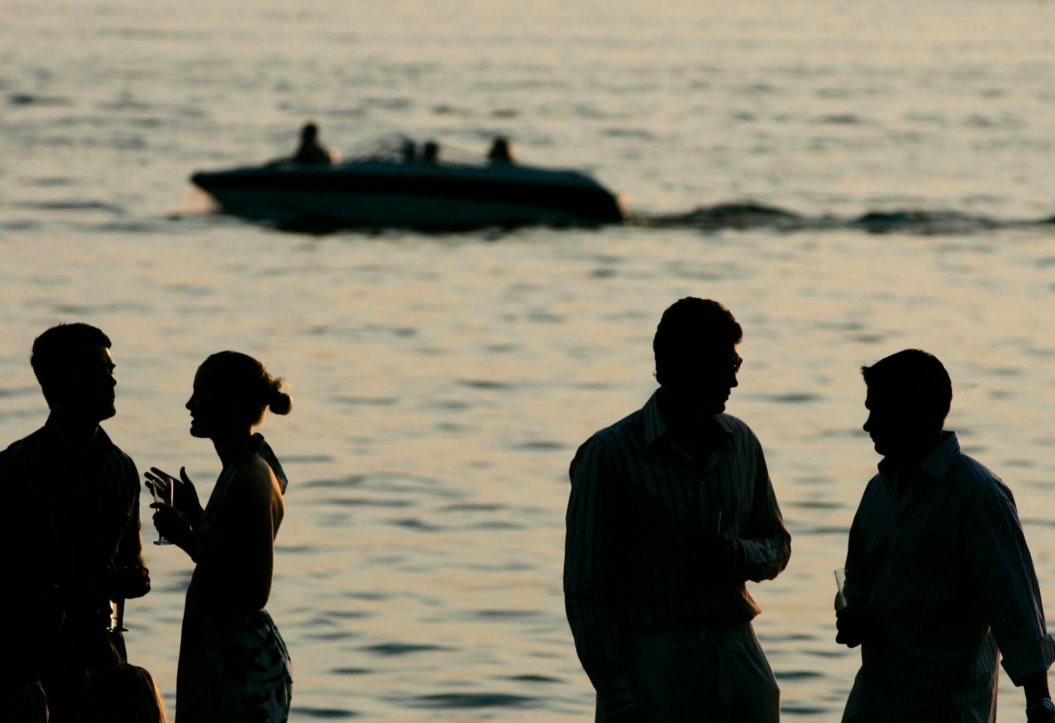 An engagement party at Tim Burton's home on Lake Minnetonka moved outdoors around dusk. Left to right, Mike Sullivan, Jenna Gettelfinger, Dave Tomassen and Nate Swanson sipped champagne in honor of Swanson and his bride-to-be, Mandy Moerchen.
