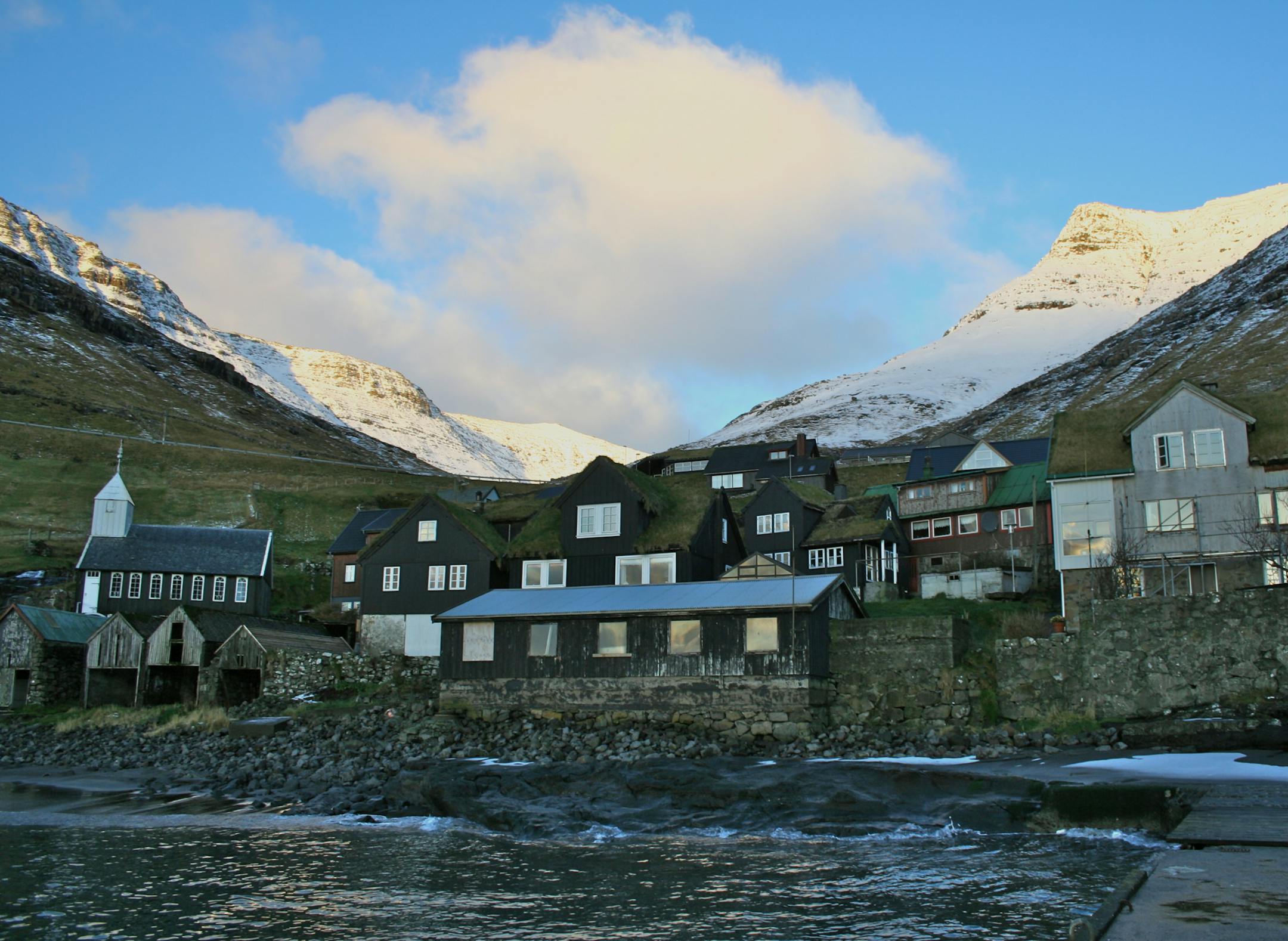Homes stand in a village on the island of Vagar in the western Faroe Islands, under the sovereignty Denmark, on Friday, Dec. 7, 2012. A proposed plan would decipher the complete DNA sequence of the 50,000 citizens of this tiny, windswept land halfway between Scotland and Iceland, from its fishermen to the prime minister. Scientists already see the Faroes becoming a model for the use of human genomes. Photographer: John Lauerman/Bloomberg