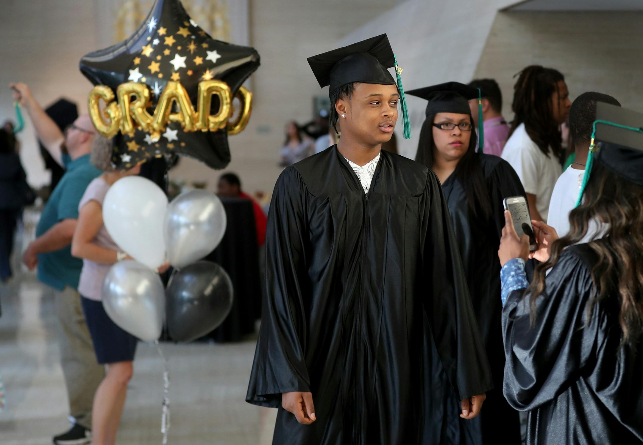 Hennepin County started a special graduation ceremony for teens who are involved with the county either through probation, foster care or being a teen parent and were honored at a special Hennepin County graduation ceremony at the Thrivent Auditorium Friday, June 2, 2017, in Minneapolis, MN. Here, Emric Howard, third from right, had his photo taken by a fellow graduate before he led the graduates into the auditorium for the ceremony.] DAVID JOLES ï david.joles@startribune.com Hennepin Count
