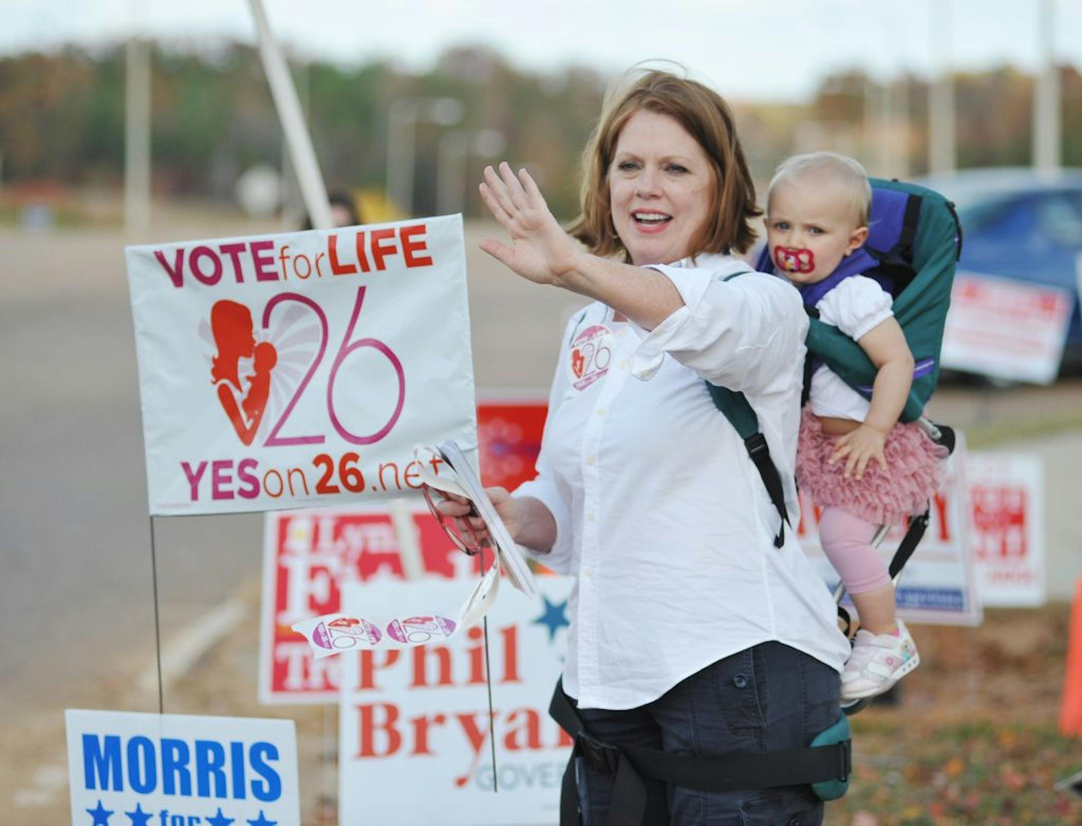 Amendment 26 supporter Joyce Haskins, with her grandchild Landry Bruce, waves to passersby outside the voting booths at the Oxford Conference Center in Oxford, Miss. on Tuesday, Nov. 8, 2011. Mississippians voted down the so-called Personhood Amendment.
