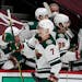 Minnesota Wild center Nico Sturm, front, is congratulated as he passes the team box after scoring a goal against the Colorado Avalanche during the thi