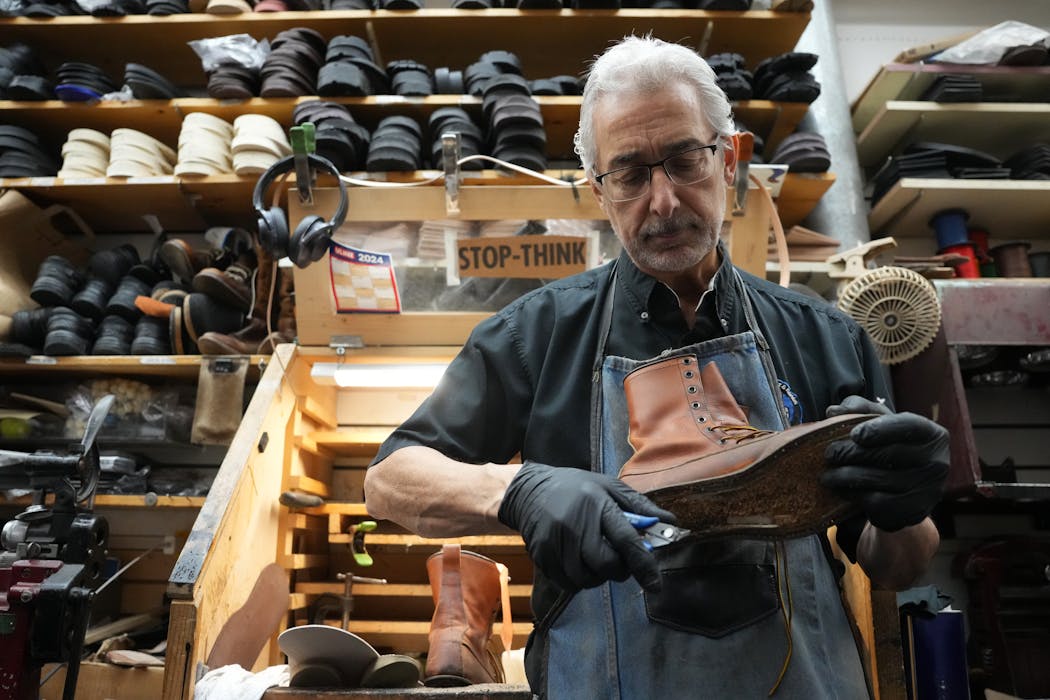 Ron George repairs a pair of boots March 6 at George's Shoes & Repair in Arden Hills, a business his grandfather started. The ongoing road construction outside on Lexington Avenue caused significant disruption for his shop that was still struggling after the COVID-19 pandemic. “It’s been a nightmare,” George said.