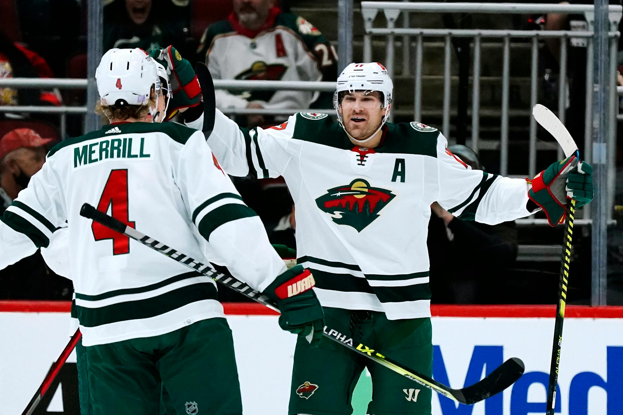 Minnesota Wild left wing Marcus Foligno, right, celebrates his goal against the Arizona Coyotes with defenseman Jon Merrill (4) during the first period of an NHL hockey game Wednesday, Nov. 10, 2021, in Glendale, Ariz. (AP Photo/Ross D. Franklin)