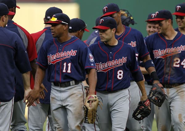 Minnesota Twins' Ben Revere (11) leads Jamey Carroll (8) and Trevor Plouffe off the field following their baseball game against the Texas Rangers Sund