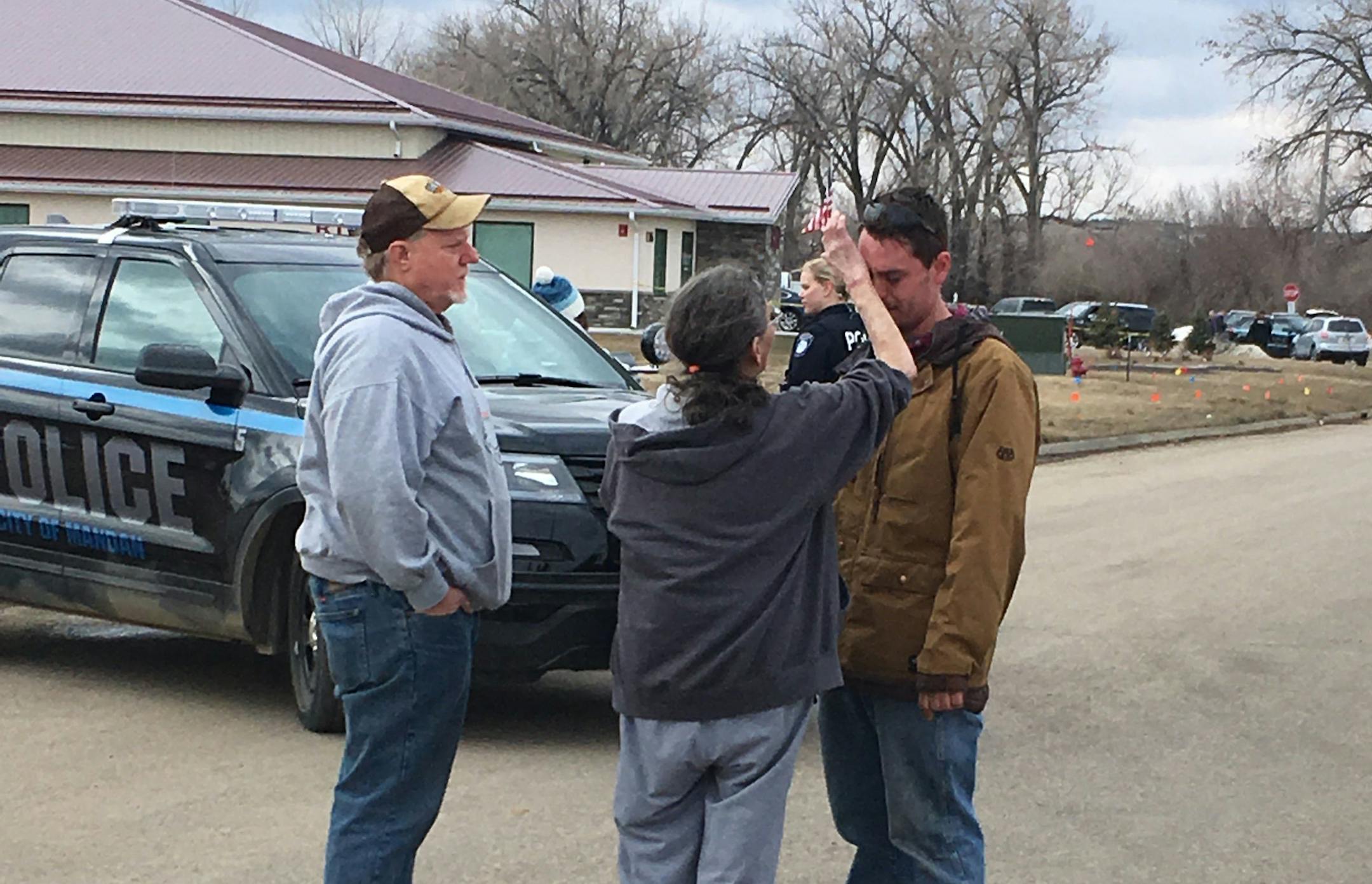 Gina Kessel, center, comforts her son Mitchell outside of RJR Maintenance and Management, a property management company, Monday, April 1, 2019, Mandan, N.D.