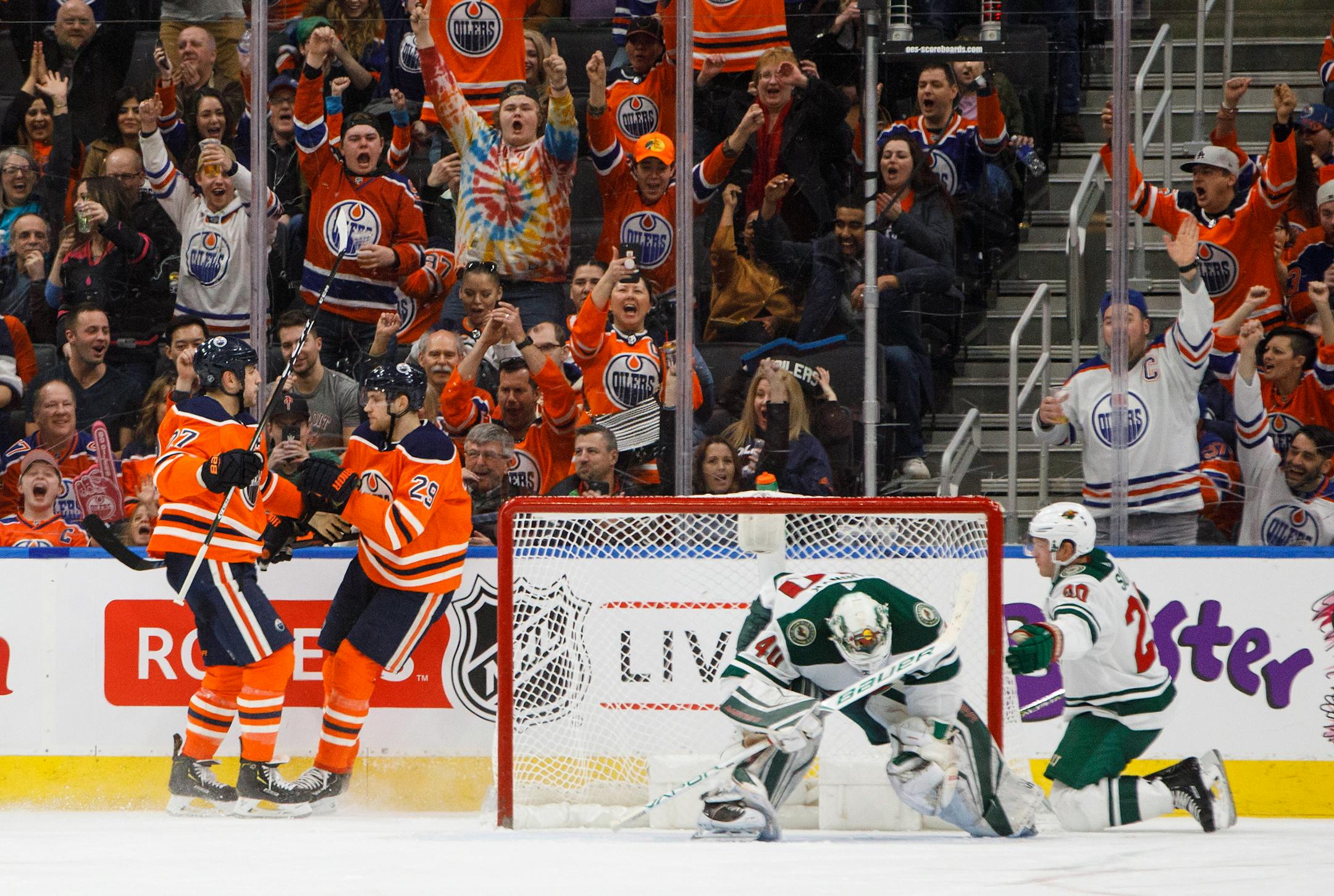 Minnesota Wild goaltender Devan Dubnyk (40) and defenseman Ryan Suter (20) react as Edmonton Oilers left wing Milan Lucic (27) and center Leon Draisaitl (29) celebrate a goal during the third period of an NHL hockey game Saturday, March 10, 2018, in Edmonton, Alberta. (Jason Franson/The Canadian Press via AP)