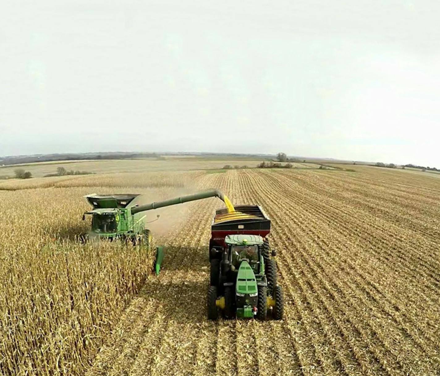 With cart in tow, the tractor autonomously navigates to a path beside the combine to allow for continuous loading.