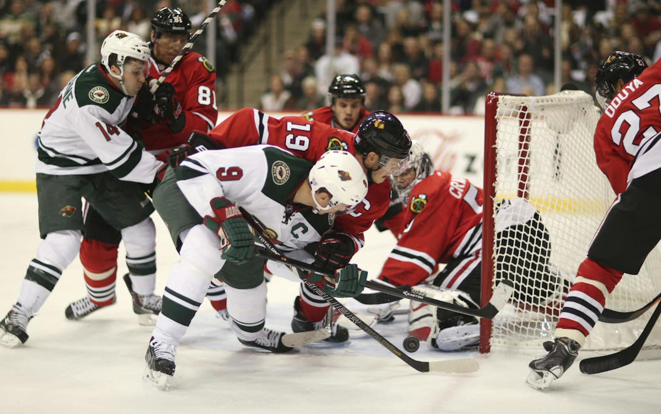 Minnesota's Mikko Koivu (9) tried to stuff the puck past Chicago goalie Corey Crawford (50).