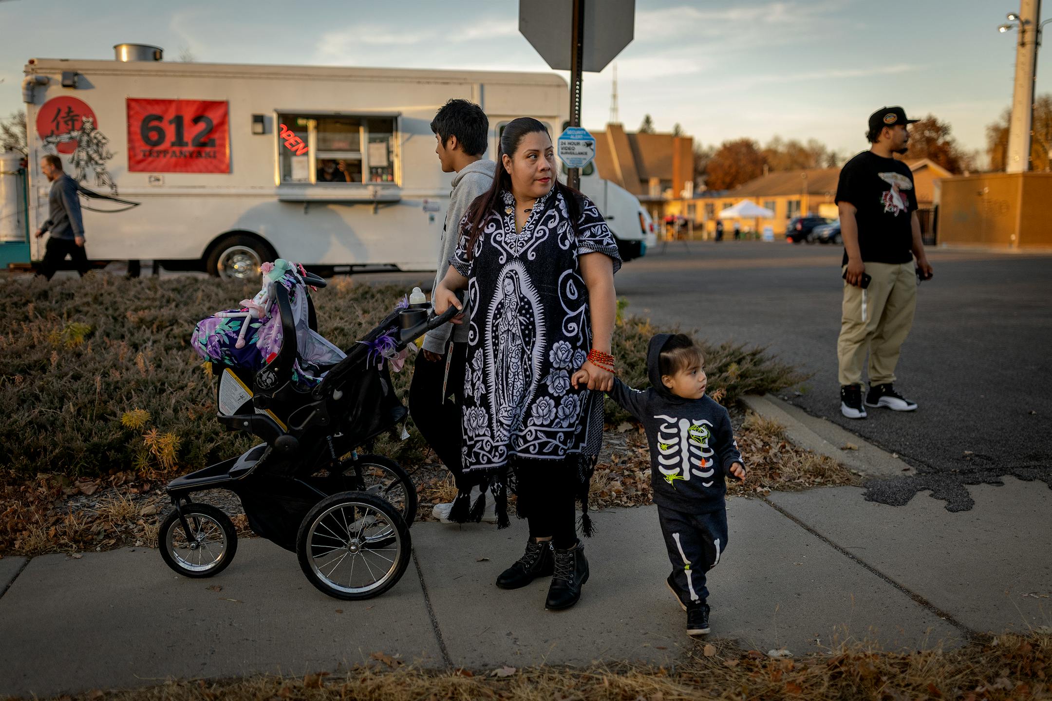 Beatriz Garcia holds her son's Jayden Garcia, 2, hand as they follow a Dia De Los Muertos procession held at El Colegio High School.