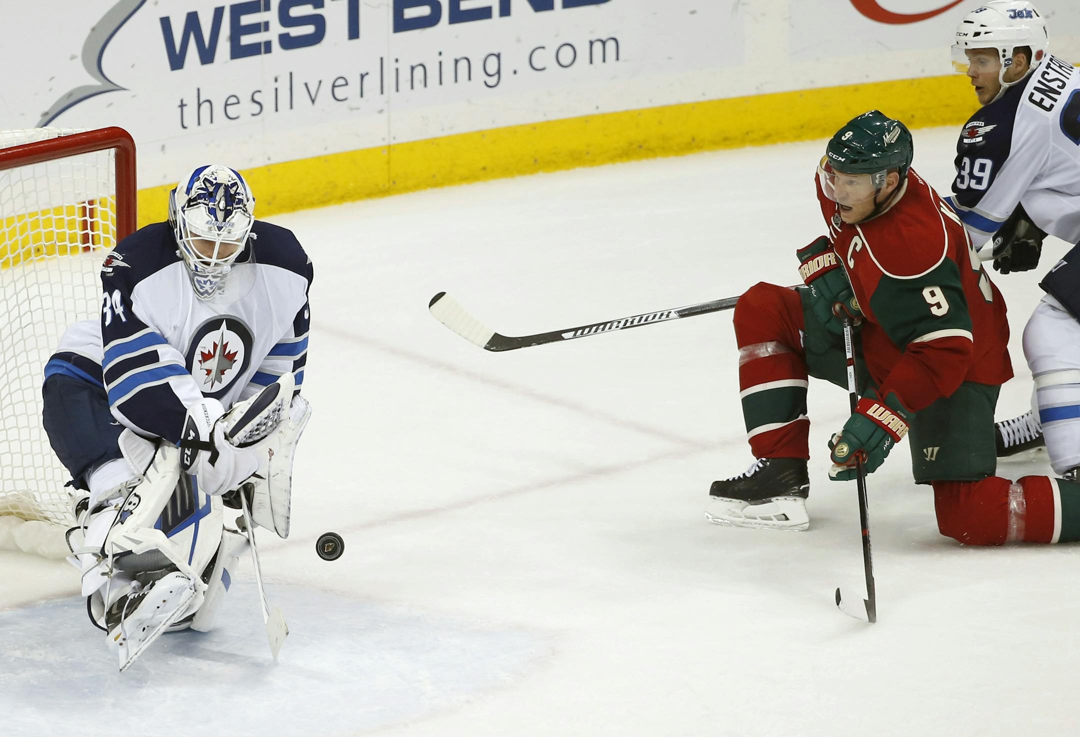 Jets goalie Michael Hutchinson deflected a shot by Wild center Mikko Koivu as Jets defenseman Tobias Enstrom (39) arrived late during the third period of the Wild's 5-3 victory at Xcel Energy Center on Tuesday night.