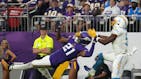 Los Angeles Chargers wide receiver Joshua Palmer (5) catches a touchdown pass off the helmet of Minnesota Vikings cornerback Akayleb Evans (21) in the