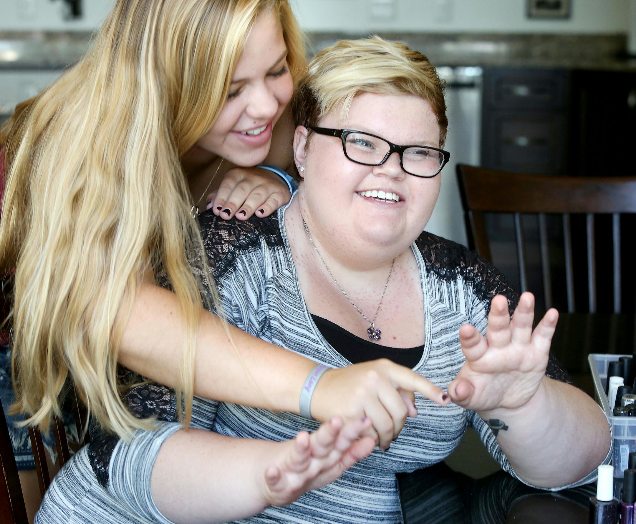 Lauren Magnuson of Duluth (left) kids Morgan Long about who did the better job on her nails on Thursday, her or Morgan's uncle Jim Pascoe. Magnuson is one of Long's best friends. Long is in hospice care at her home because she is terminally ill with brain cancer. Mandatory credit: Duluth News Tribune/ Bob King / rking@duluthnews.com