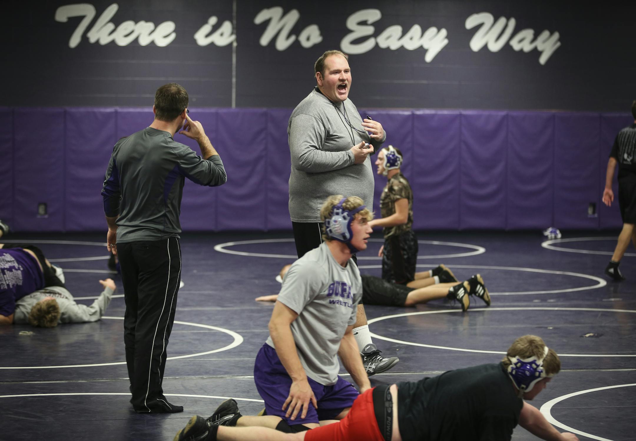 Buffalo wrestling coach Jason Maurer and assistant coach (at left) Chris Lian during wrestling practice at Buffalo High School in Buffalo, Minn., on Thursday, December 4, 2014. ] RENÉE JONES SCHNEIDER reneejones@startribune.com Maurer is still recovering after he went into full cardiac arrest during softball game last May.