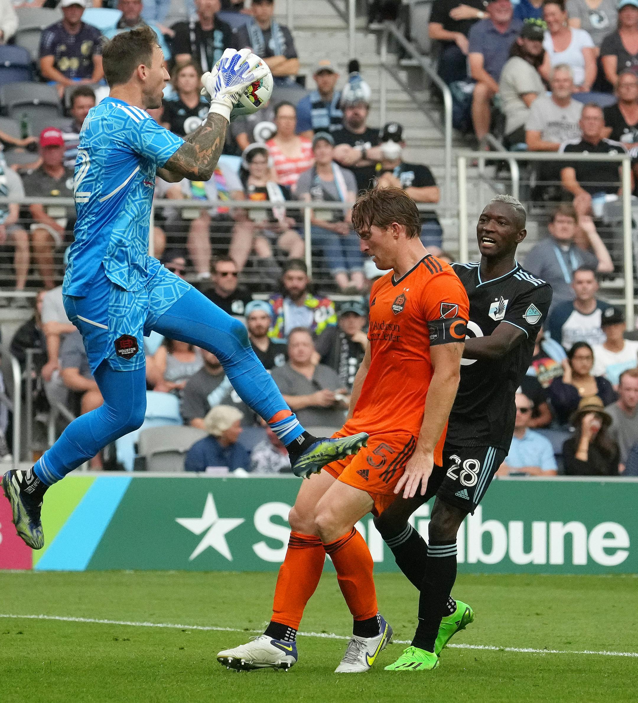 Houston Dynamo defender Tim Parker (5) puts the breaks on Minnesota United forward Mender Garcia (28) as goalkeeper Steve Clark (12) goes up for the save in the second half of an MLS game between Minnesota United and the Houston Dynamo.