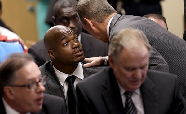 Minnesota Vikings running back Adrian Peterson, left, listens to attorney Brian Wice, right, while making his first court appearance Wednesday, Oct. 8