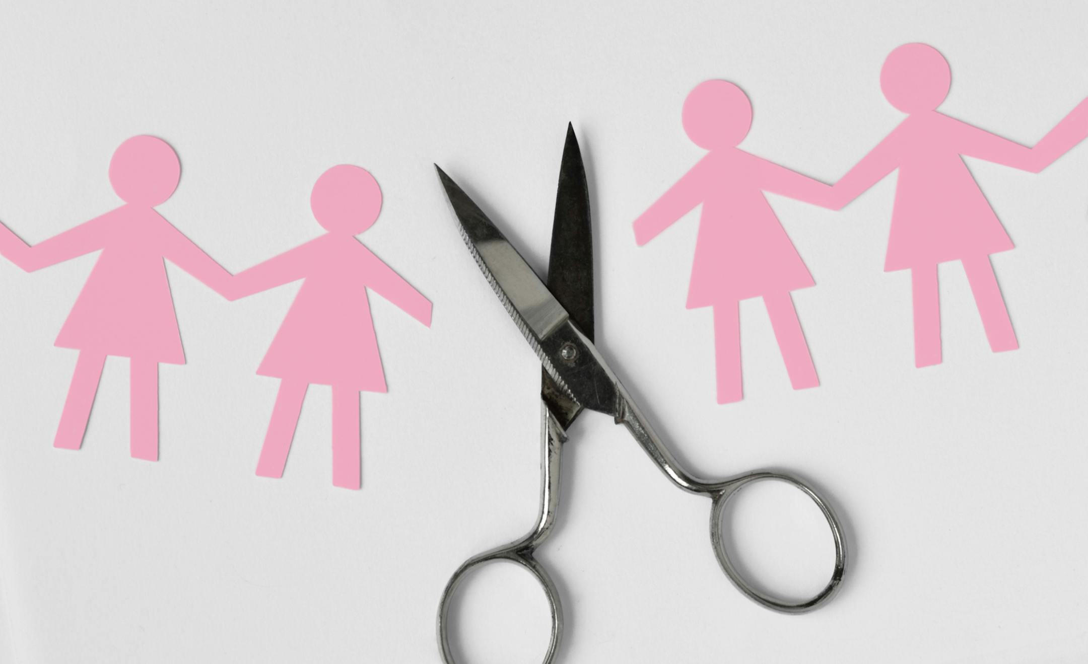 Broken women paper chain with scissors on white background - Broken relationships between woman concept