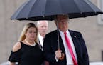 FILE - In this Aug. 24, 2016 file photo, Republican presidential candidate Donald Trump walks in the rain with Florida Attorney General Pam Bondi as t