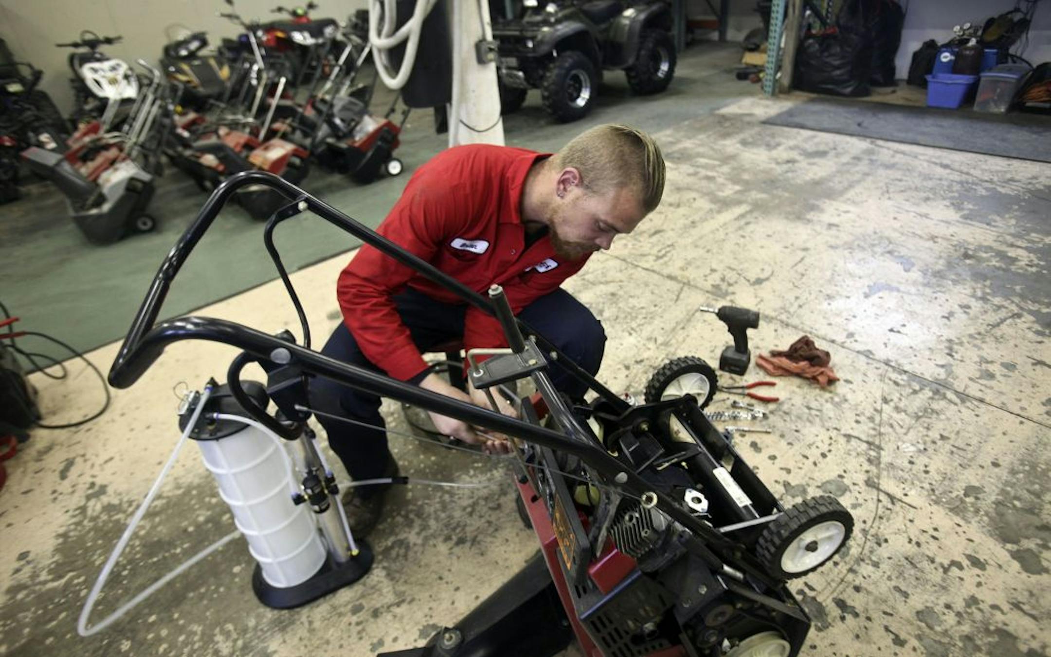 Brian Ledbeter, owner of Peak Performance Power Sports, drained out year-old gas from one of the many snowblowers at his shop in Fridley Tuesday, November 8, 2011.