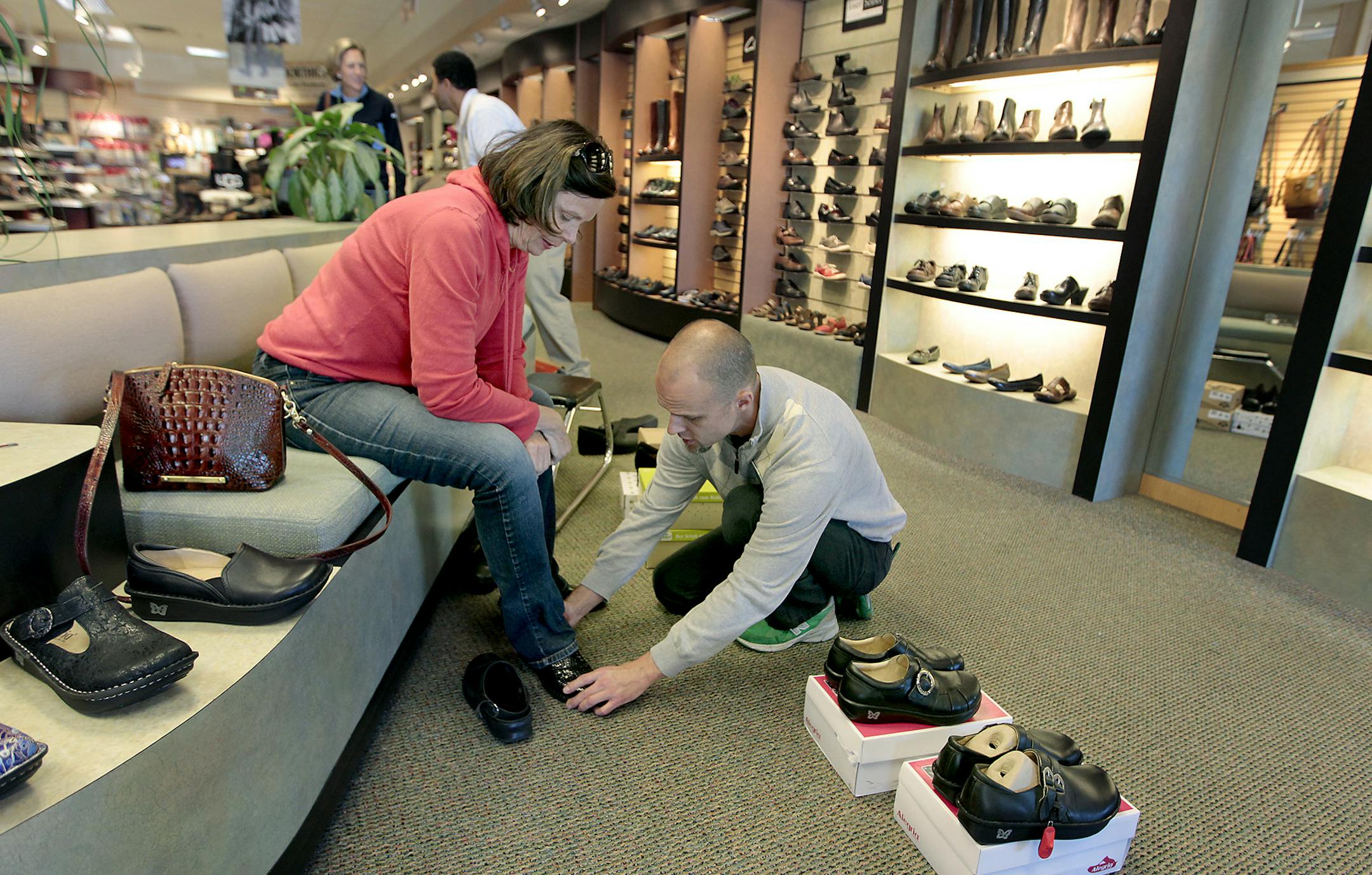 Mary Perkins, left, received help from shoe salesperson Matt Morseth at Schuler Shoes, Wednesday, October 15, 2014 in St. Louis Park, MN. Schuler Shoes celebrates its 125th year in business this year, a remarkable feat, considering the dwindling number of family-owned, independent shoe stores.