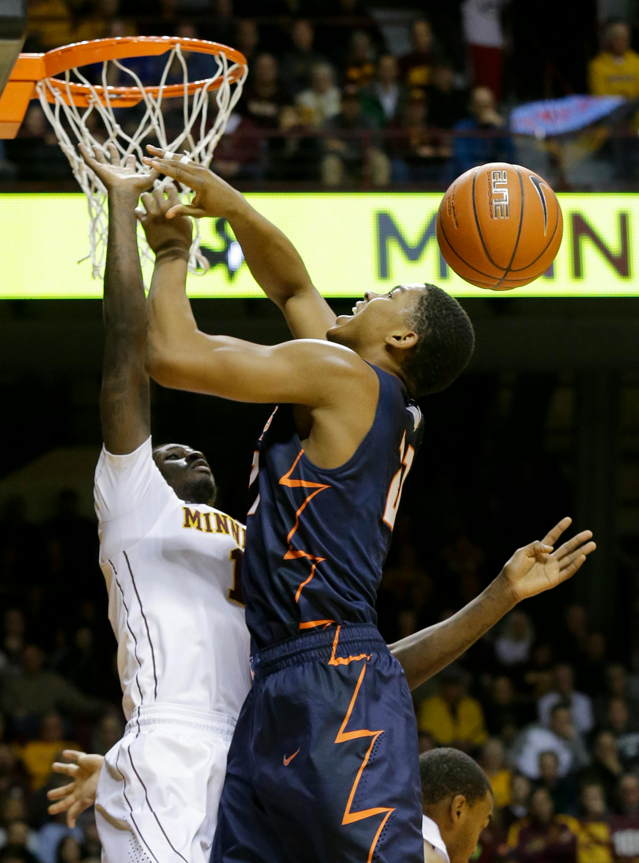 Illinois guard Malcolm Hill, right, loses control of the ball as he is fouled by Minnesota guard Carlos Morris, left, during the first half of an NCAA college basketball game in Minneapolis, Saturday, Jan. 24, 2015. Minnesota won 79-71. (AP Photo/Ann Heisenfelt)
