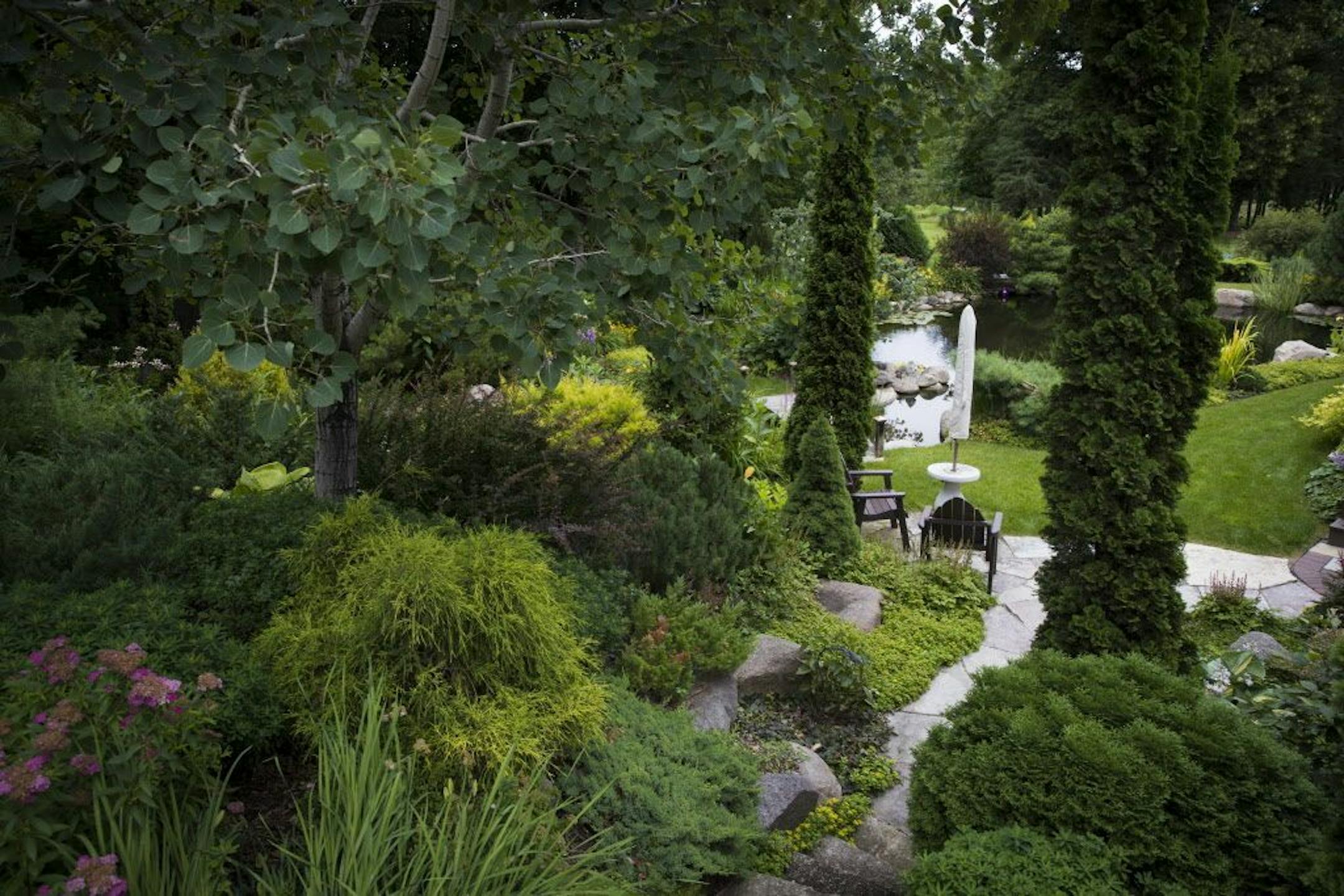 Columnar evergreens punctuate the flowers and foliage.