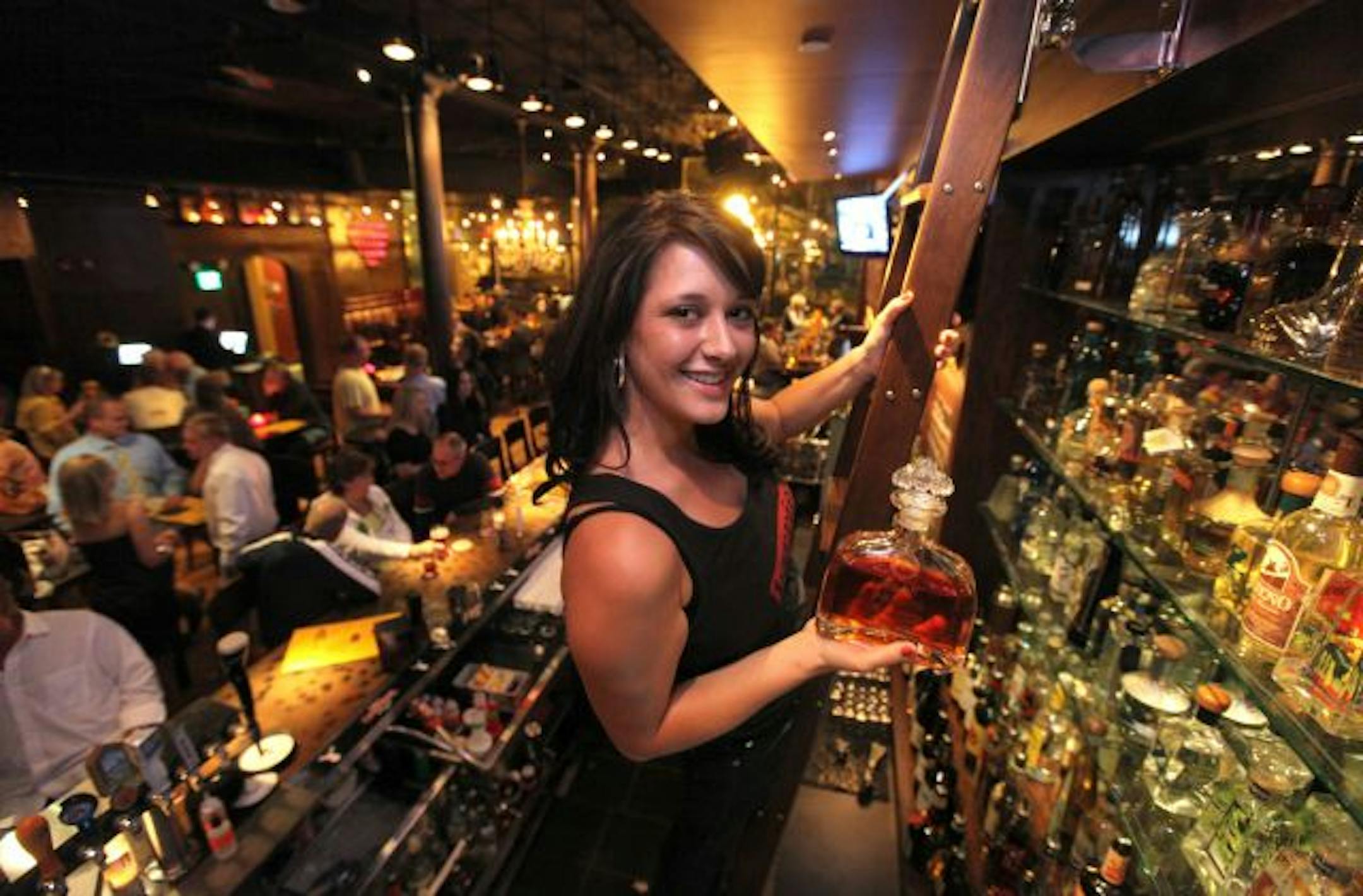 The second Barrio in downtown St. Paul. The scene inside and bartender Jennifer Berg Pulls out one of the attractions, a high-end tequila.