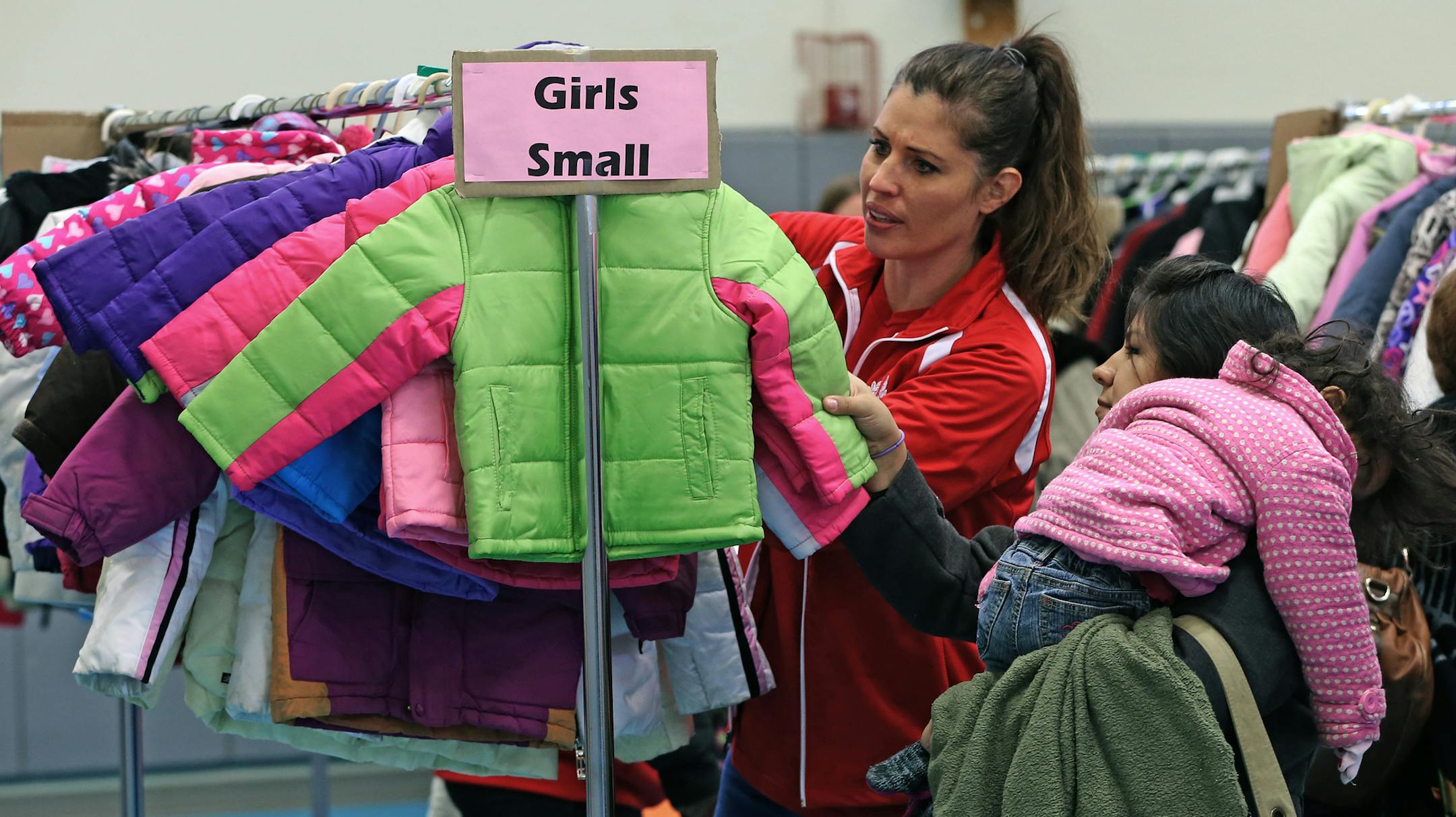 Volunteer Lisa Drevlow helped Valentina Zaragoza pick out a winter coat for her daughterm Liliana, 2.