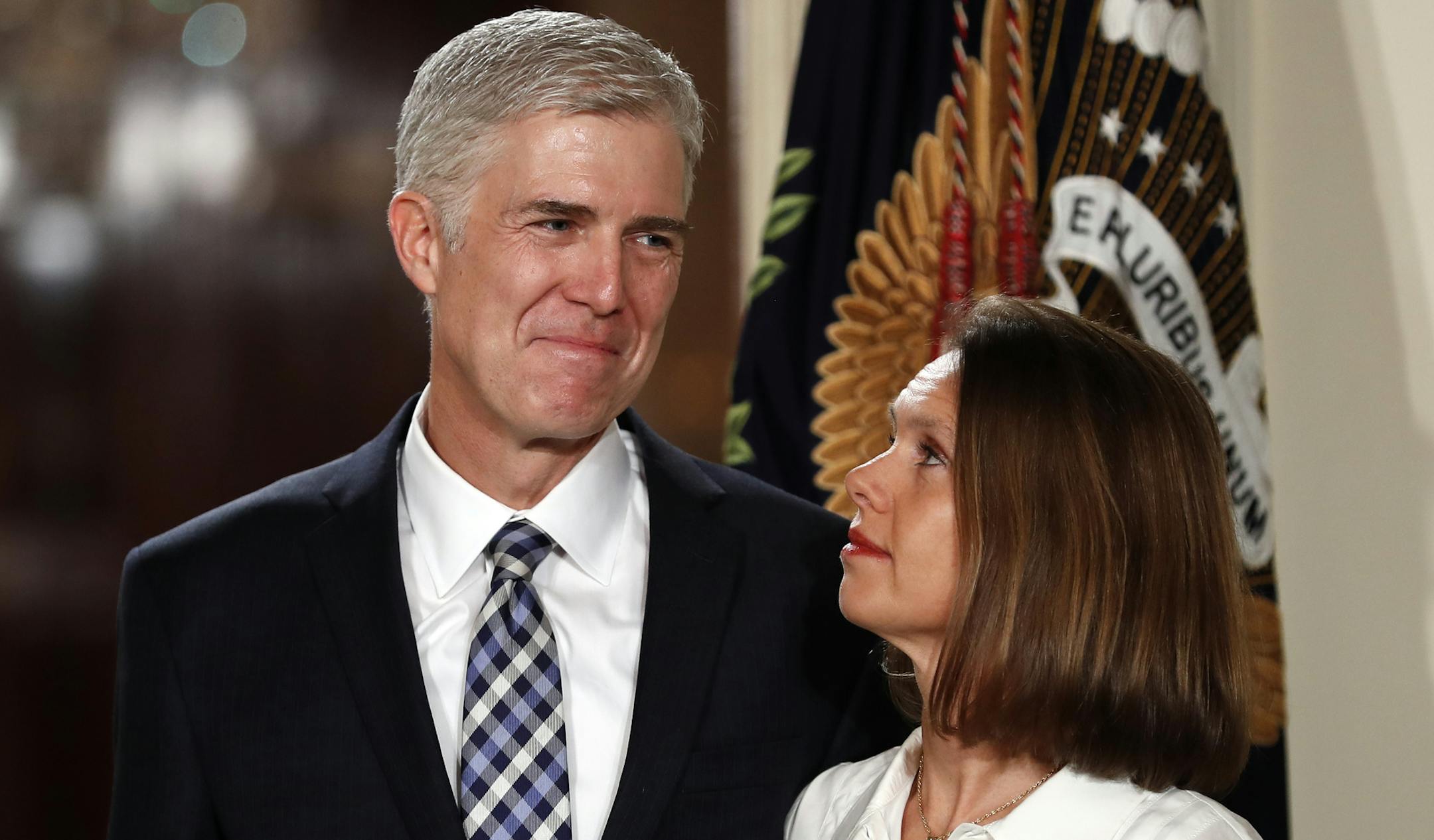 FILE - In this Jan. 31, 2017, file photo, Judge Neil Gorsuch stands with his wife Louise as President Donald Trump announces him as his choice for the Supreme Court in the East Room on the White House in Washington. Gorsuch is roundly described by colleagues and friends as a silver-haired combination of wicked smarts, down-to-earth modesty, disarming warmth and careful deliberation. His critics largely agree with that view of the self-described “workaday judge” in polyester robes.