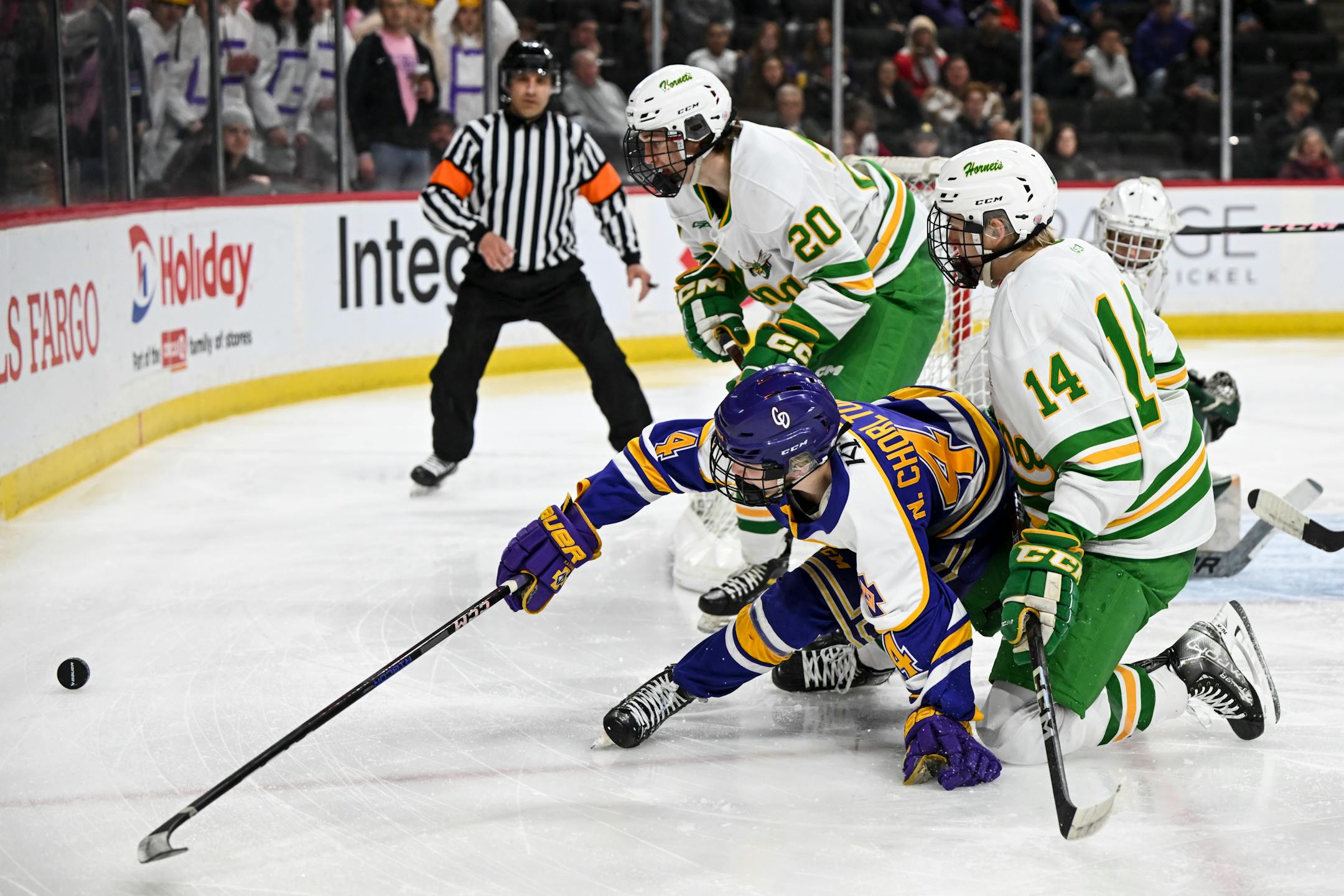 Cretin-Derham Hall forward Nate Chorlton (4) chases the puck against Edina defenseman Mikey Mason (20) and defenseman Charlie Sandven (14) during the first period.