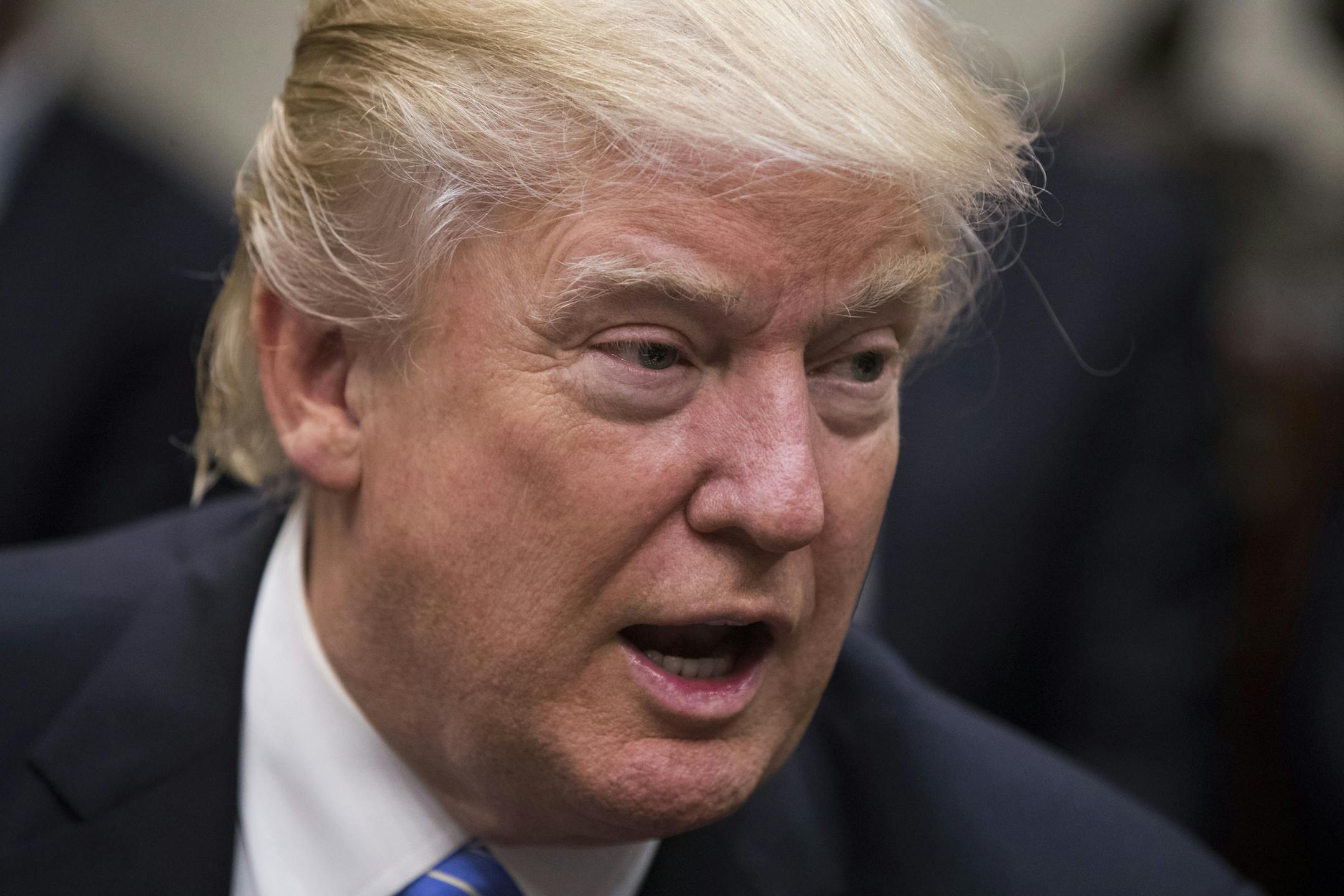 President Donald Trump speaks to reporters during a breakfast with business leaders in the Roosevelt Room of the White House, in Washington, Jan. 23, 2017. Also pictured is Wendell Weeks, left, chief executive of Corning Inc., and Alex Gorsky, right, chief executive of Johnson & Johnson. (Doug Mills/The New York Times)