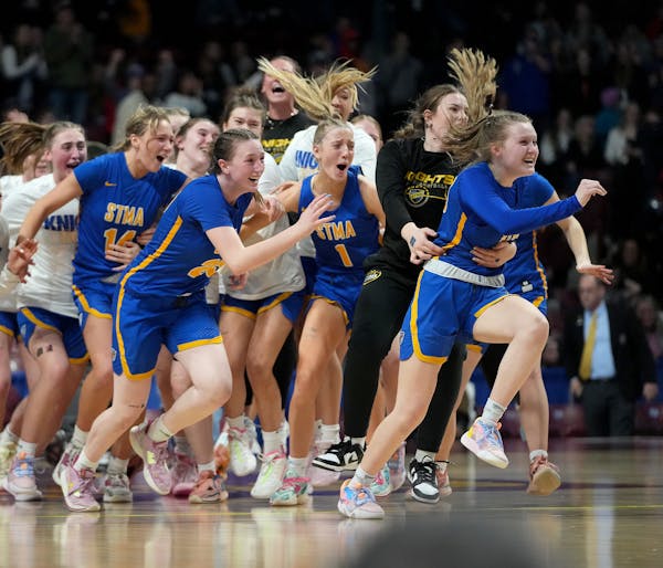St. Michael-Albertville players celebrate their thrilling 71-70 win over Hopkins' Kelly Boyle  Saturday, March 18, 2023 during the first half of the C