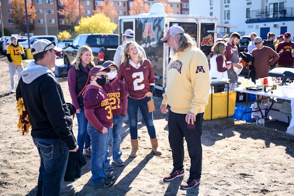 Jerry Kieft greeted quarterback Tanner Morgan’s mother, Pat (No. 2 jersey), and family friends Jaxon and Jace Trettin before the Oct. 23 game agains