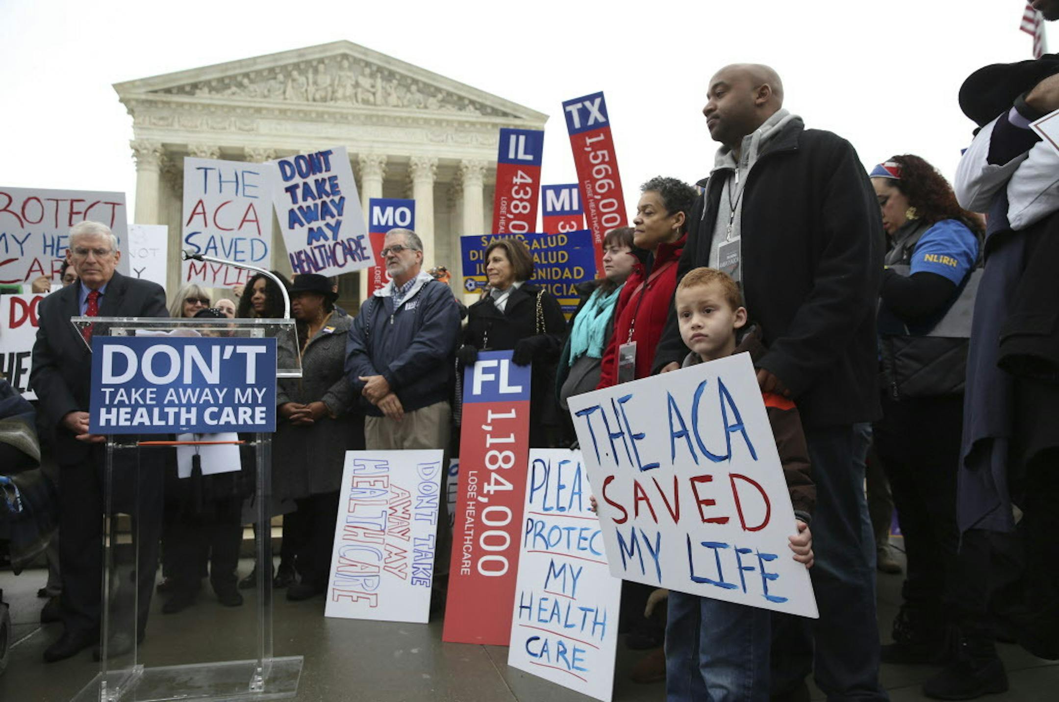 James Cook, of Cleveland, and his son Jumaane, 5, stand with signs amongst other protesters outside the Supreme Court on Wednesday morning in Washington, March 4, 2015. The fight over the Affordable Care Act returns to the Supreme Court as the justices hear arguments in a conservative challenge that could determine the future of the insurance program that now covers millions of people. (Doug Mills/The New York Times)
