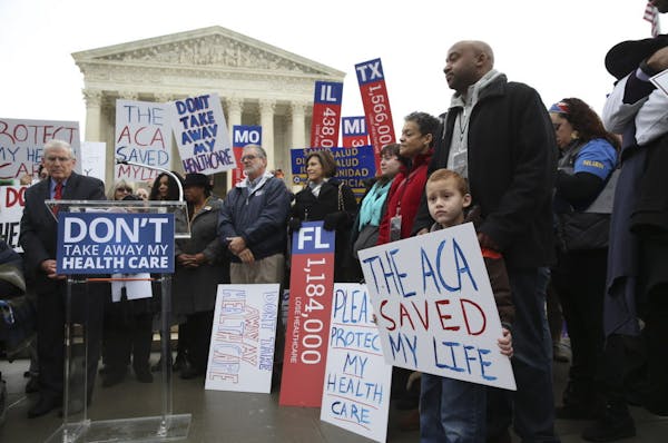 James Cook, of Cleveland, and his son Jumaane, 5, stand with signs amongst other protesters outside the Supreme Court on Wednesday morning in Washingt