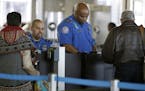 In this Nov. 25, 2015 photo, Transportation Security Administration agents check travelers identifications at a security check point at O'Hare Interna