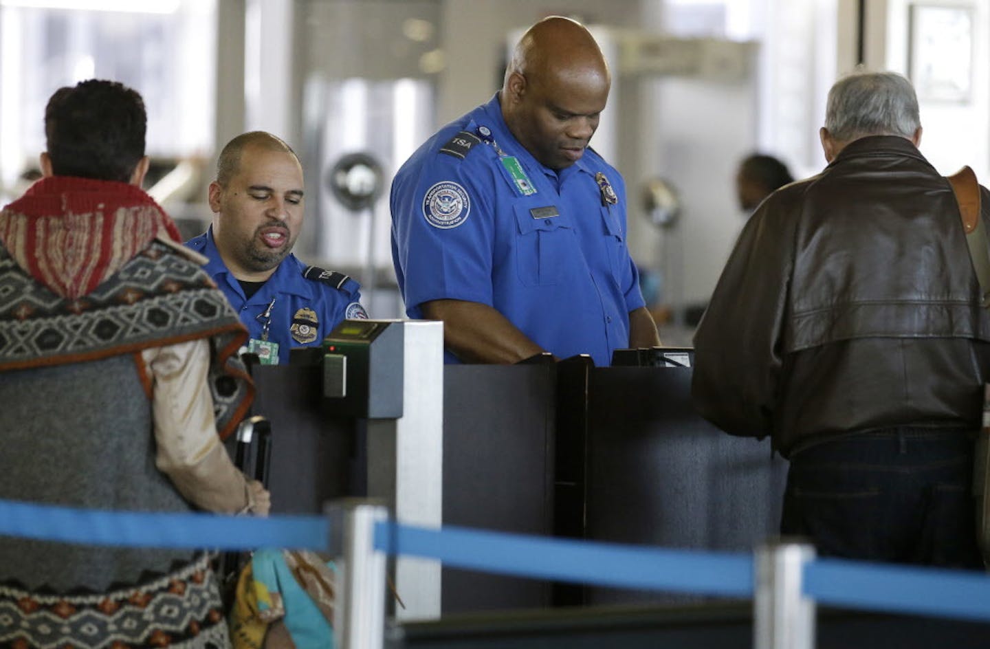 In this Nov. 25, 2015 photo, Transportation Security Administration agents check travelers identifications at a security check point at O'Hare International Airport in Chicago.