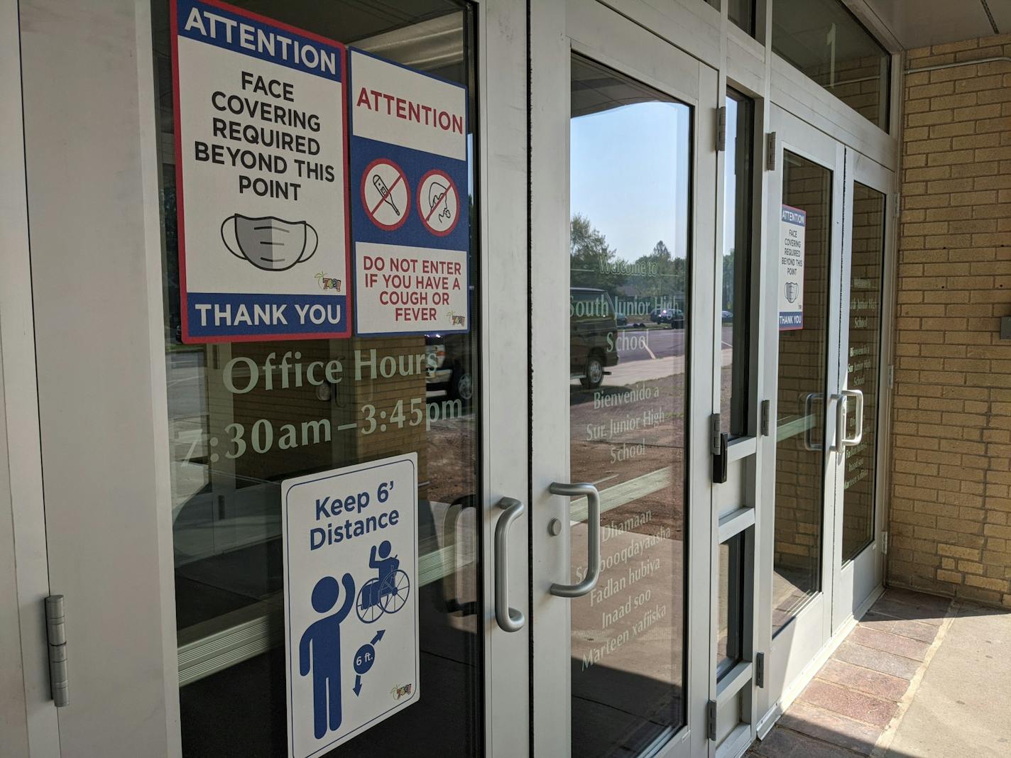 Signs relating to pandemic safety requirements plaster the doors at South Junior High in St. Cloud. (Credit: Jenny Berg)