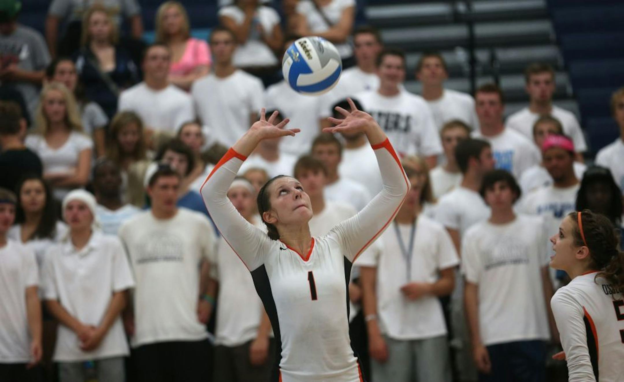 Osseo's Megan Pekarek set the ball for teammate during their game with Blaine on Tuesday September 10, 2013.