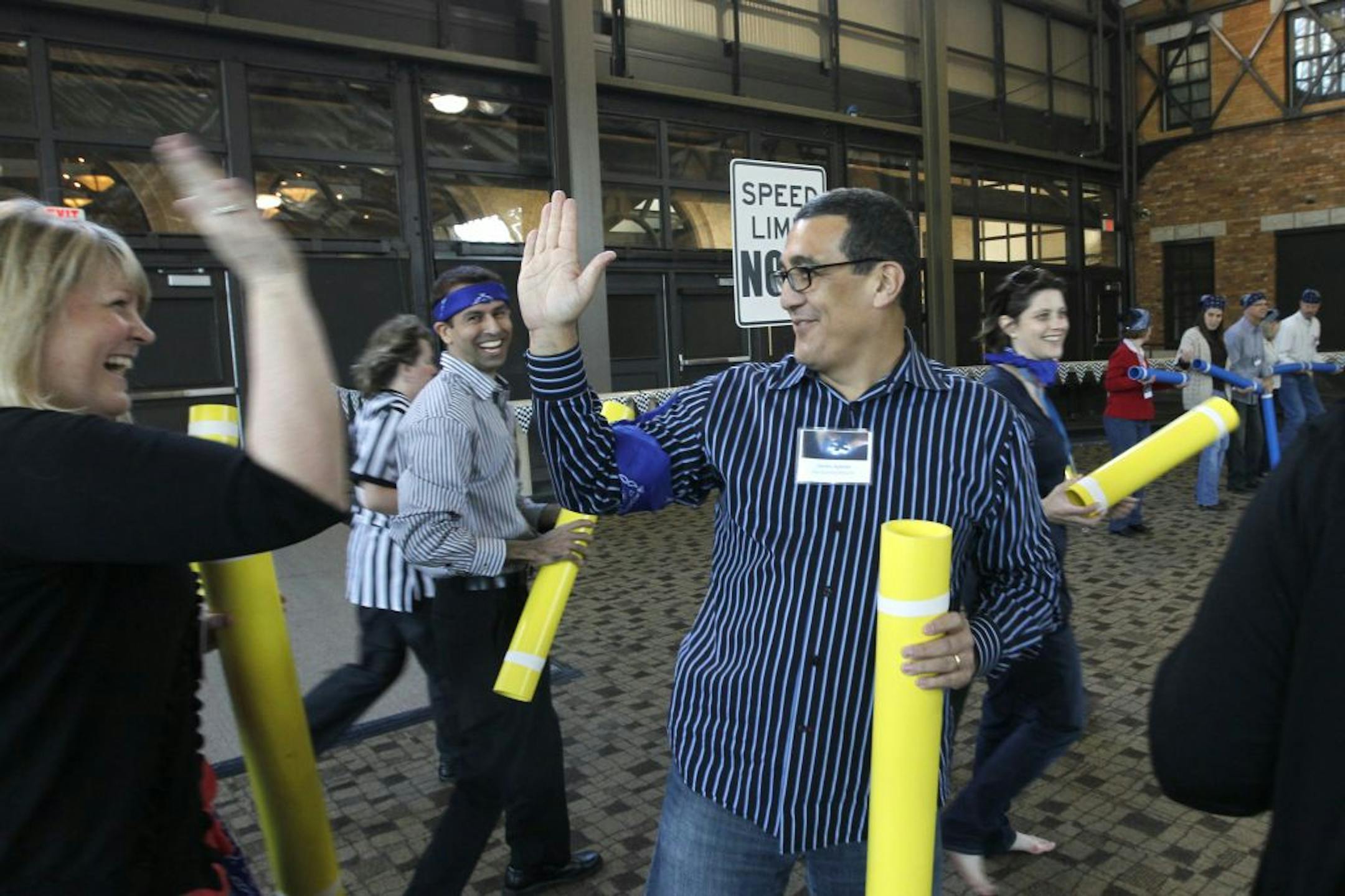 Ruth Hendrickson and Carlos Adame celebrated after completing a team-building game that earned points for the bike parts they needed in order to assemble bicycles for needy children last week.