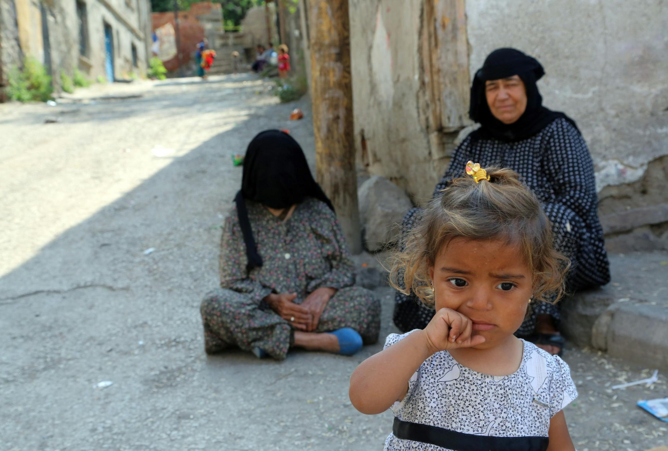 Syrian refugees sit in front of a derelict building in Haci Bayram neighborhood in Ankara, Turkey, Monday, July 27, 2015. The number of Syrian refugees in Turkey is estimated to be close to two million but only about 200,000 of them live in refugee camps. Some family live in makeshift shelters. Turkey hosts the largest number of refugees, according to recent U.N. figures.(AP Photo/Burhan Ozbilici)