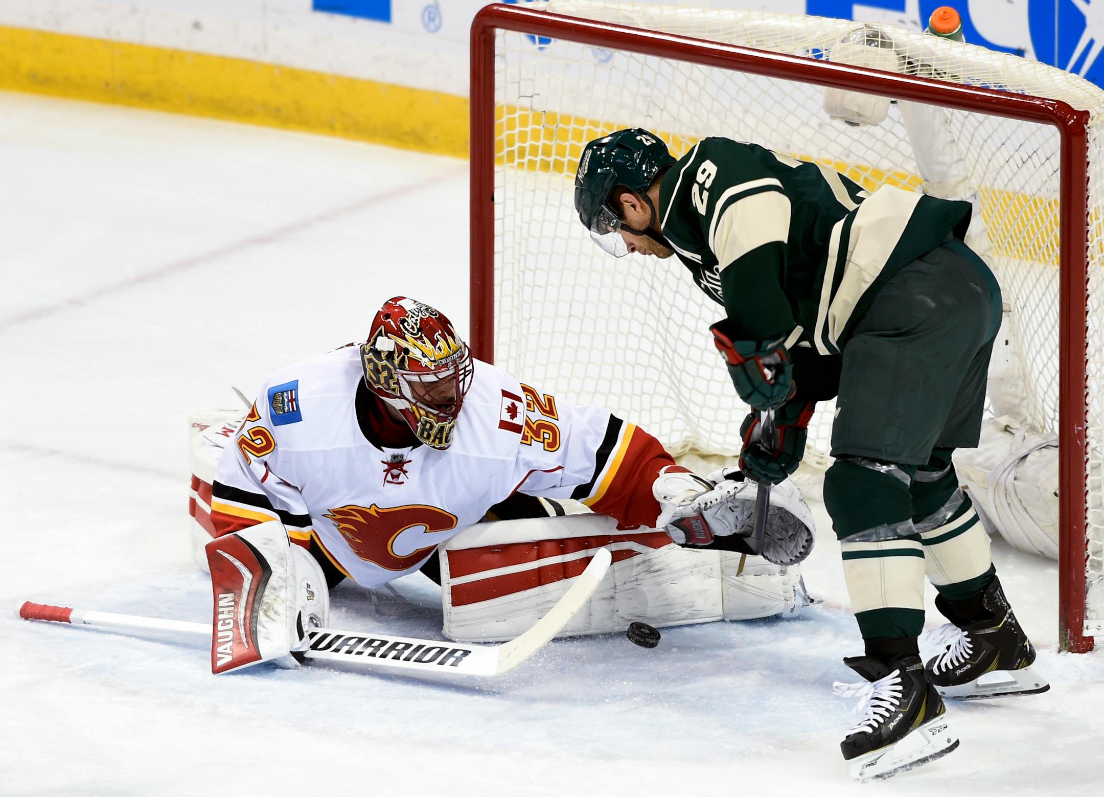 Calgary Flames goalie Niklas Backstrom (32), of Finland, blocks a shot by Minnesota Wild right wing Jason Pominville (29) during the first period of an NHL hockey game Saturday, April 9, 2016, in St. Paul, Minn. (AP Photo/Hannah Foslien)