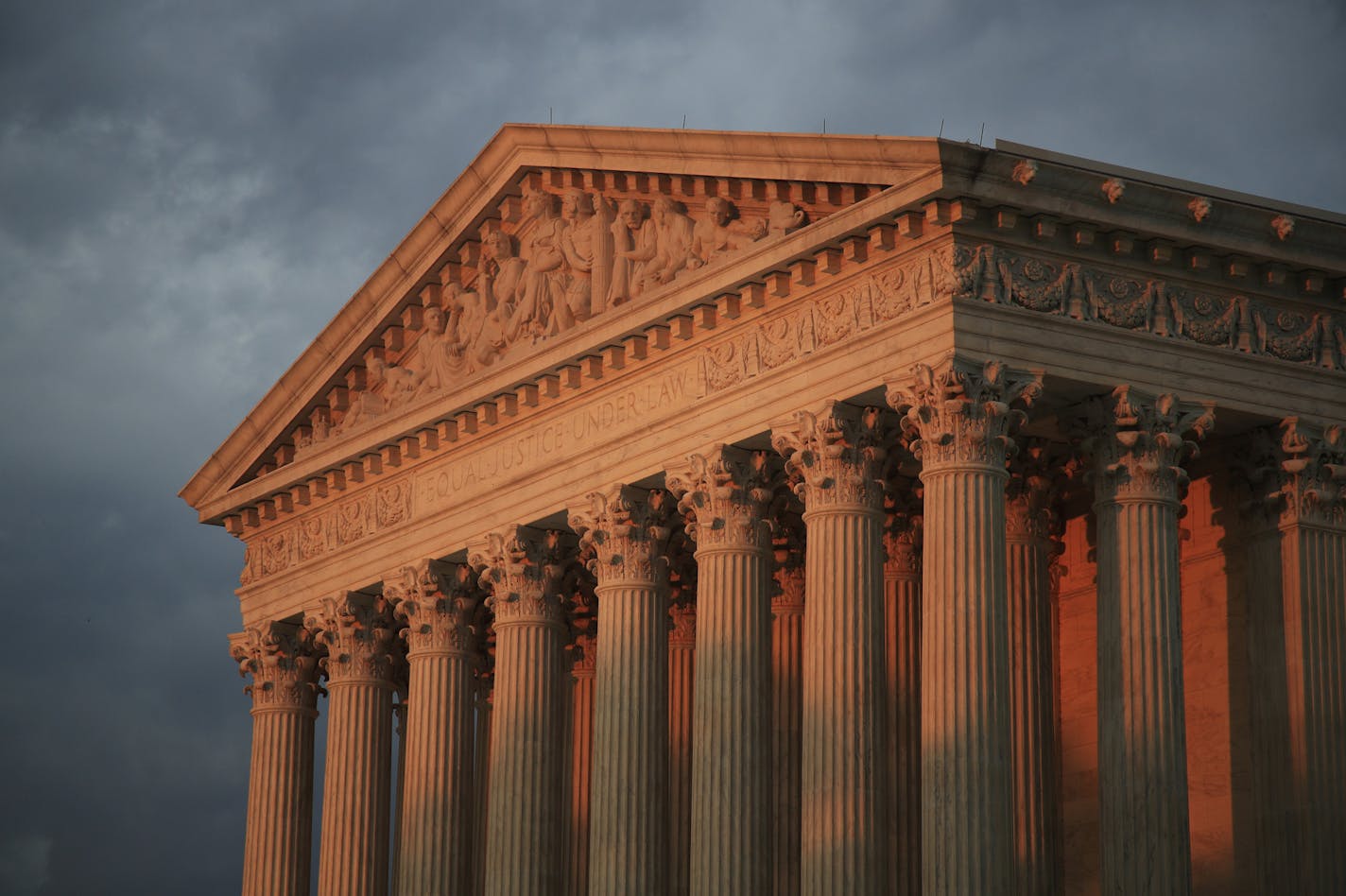 FILE - This Oct. 4, 2018, file photo shows the U.S. Supreme Court at sunset in Washington. More than 200 corporations have signed a friend-of-the-court brief urging the U.S. Supreme Court to rule that federal civil rights law bans job discrimination on the basis of sexual orientation and gender identity. The brief, announced Tuesday, July 2, 2019 by a coalition of five LGBTQ-rights groups, is being submitted to the Supreme Court this week ahead of oral arguments before the justices this fall on