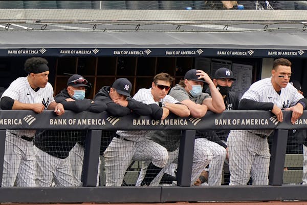 New York Yankees players lean on the dugout railing during the seventh inning of a loss to the Tampa Bay Rays in a baseball game, Sunday, April 18, 20