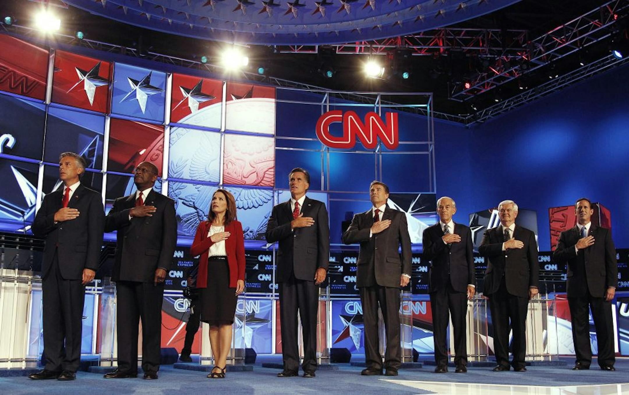 Republican presidential candidates, from left, Utah Gov. Jon Huntsman, businessman Herman Cain, Rep. Michele Bachmann, R-Minn., former Massachusetts Gov. Mitt Romney, Texas Gov. Rick Perry, Rep. Ron Paul, R-Texas, former House Speaker Newt Gingrich, and former Pennsylvania Sen. Rick Santorum, sing the National Anthem before a Republican presidential debate Monday, Sept. 12, 2011, in Tampa, Fla.