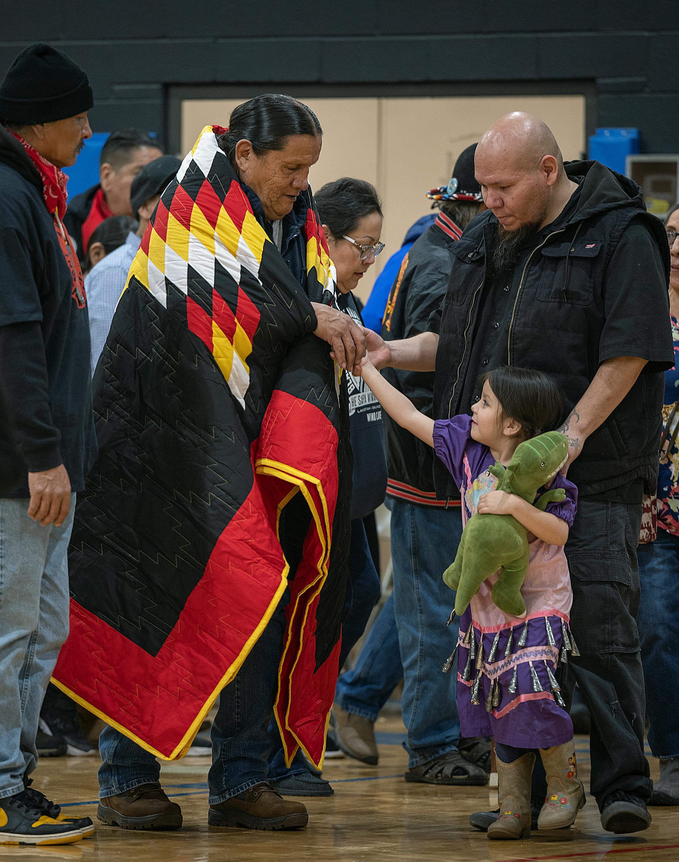 Tom Cheyenne is covered with a blanket as he is honored during a Pow Wow to honor the 50th Anniversary of the AIM Warriors of Wounded Knee of 1973 in Rapid City, SD.