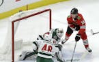 Minnesota Wild's Devan Dubnyk (40) deflects Chicago Blackhawks' Jonathan Toews' shot wide of the net as Jared Spurgeon (46) also defends during the fi