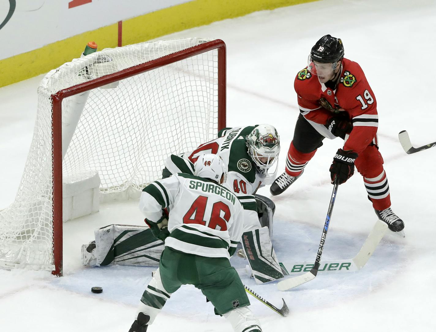 Minnesota Wild's Devan Dubnyk (40) deflects Chicago Blackhawks' Jonathan Toews' shot wide of the net as Jared Spurgeon (46) also defends during the first period of an NHL hockey game Wednesday, Jan. 10, 2018, in Chicago. (AP Photo/Charles Rex Arbogast)